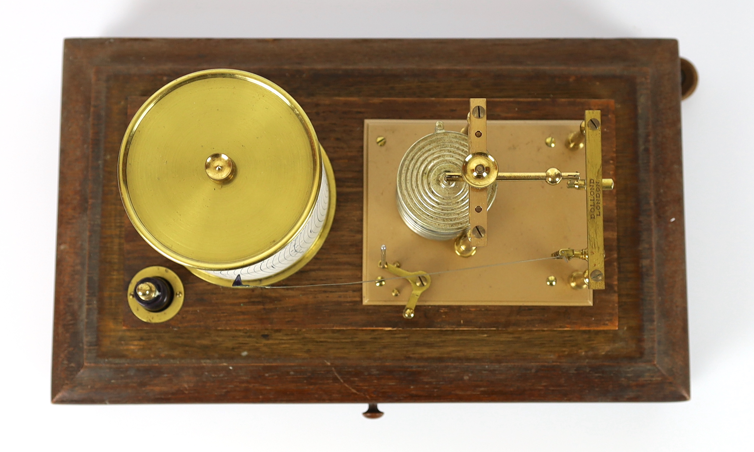 A barograph by Dollond in an oak case with bevelled glass panels and incorporating an ink bottle and a drawer with spare graph papers, 36.5cm x 21.5cm